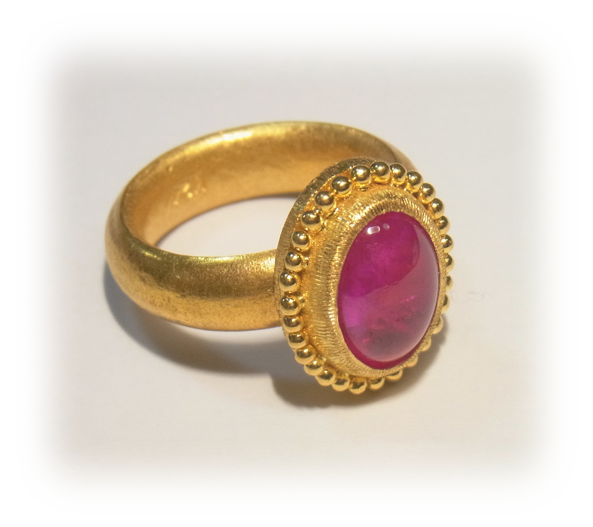 Gold ring with cabochon-cut ruby(overall), granulated gold trim around the bezel. 1